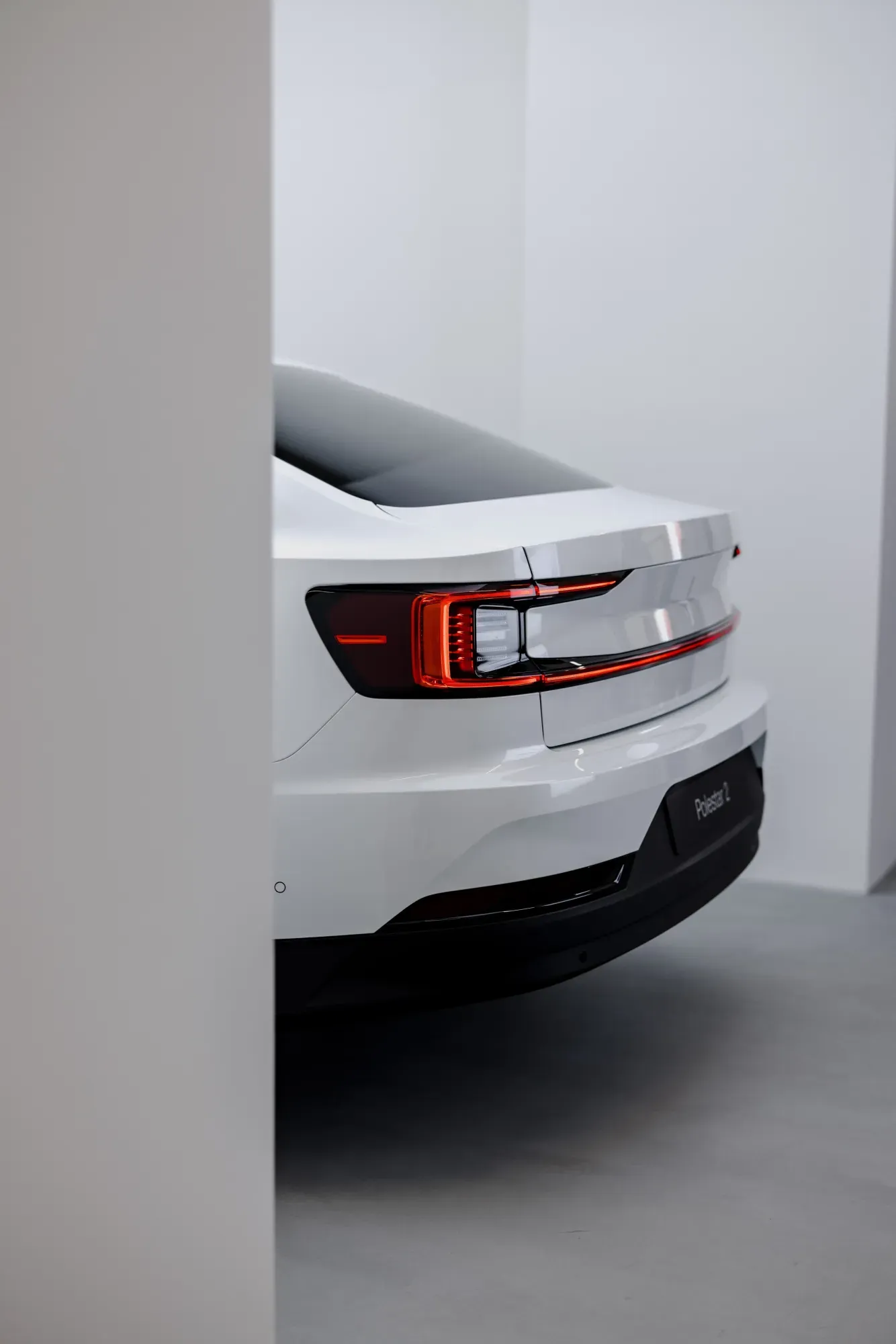 The back of a car sticks out from behind a wall.